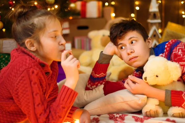 男孩和女孩在新年装饰中的肖像 他们撒谎 吃糖果和饼干 节日灯饰 礼物和装饰玩具的圣诞树 — 图库照片