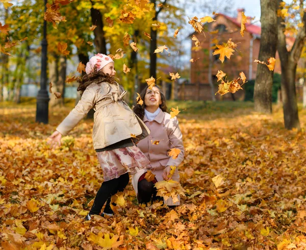 妈妈和女儿在玩黄色落叶游戏 一个快乐的人在秋天公园的画像 — 图库照片