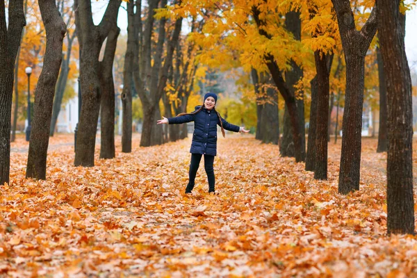 一个小女孩在秋天的城市公园里散步的画像 美丽的大自然 黄叶的树木 — 图库照片
