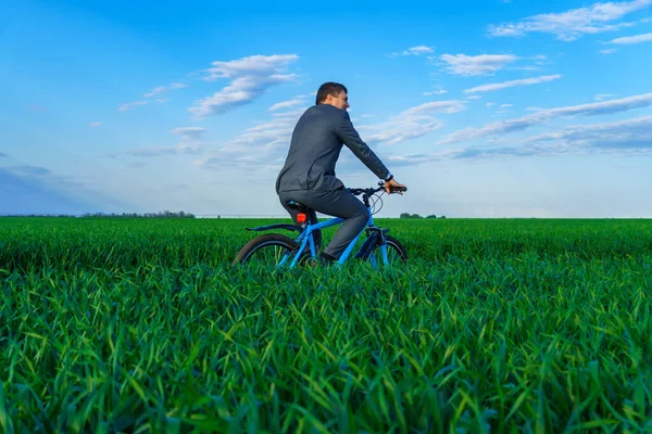 Business Concept Businessman Rides Bicycle Green Grass Field Looks Distance — Stock Photo, Image