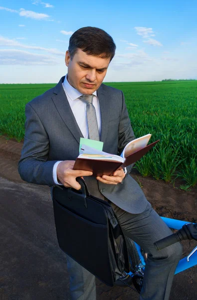 Business Concept Businessman Rides Bicycle Green Grass Field Takes Diary — Stock Photo, Image