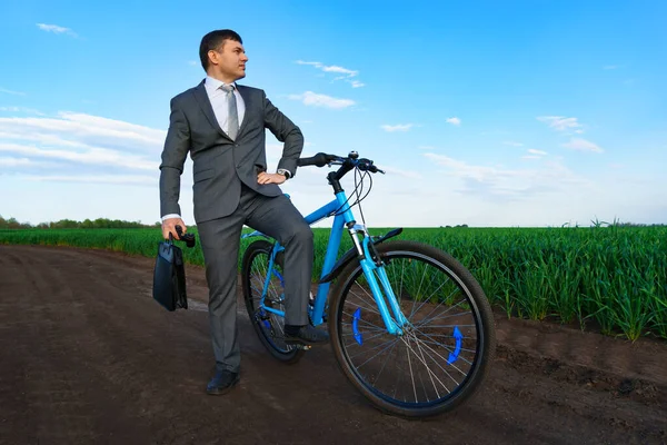 사업가가 밭에서 사업용 양복을 자전거를 다니면서 서류를 가지고 — 스톡 사진