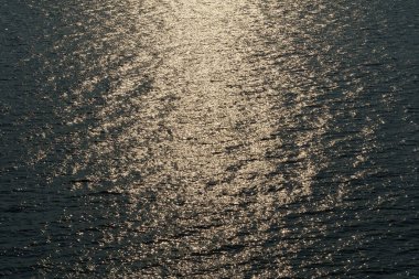 Altın güneş ışığı günbatımında bir dalgaya yansıyor, koyu renk zıtlık arka plan deniz manzarası, üst manzara, güzel deniz manzarası