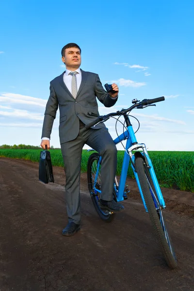 원거리를 쌍안경으로 사업가 밭에서 자전거를 다니며 사업용 양복을 서류를 가지고 — 스톡 사진