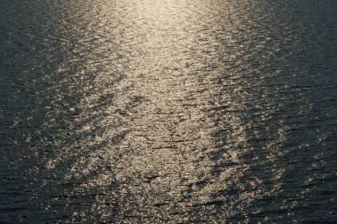 Altın güneş ışığı günbatımında bir dalgaya yansıyor, koyu renk zıtlık arka plan deniz manzarası, üst manzara, güzel deniz manzarası