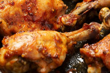 Kızarmış tavuk budu, aromatik kabuklu, fırın tepsisinde pişmiş et, yakın görüşte lezzetli yemekler.