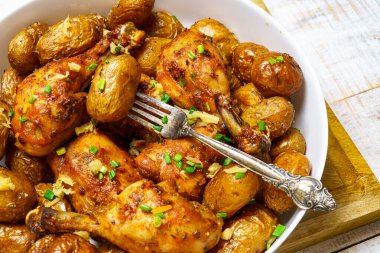 Kırsal tarzda lezzetli bir öğle yemeği, sağlıklı yiyecekler kızarmış tavuk eti ve soyulmamış kızarmış patates, doğranmış pırasa, arka plan olarak pişmiş yemek.