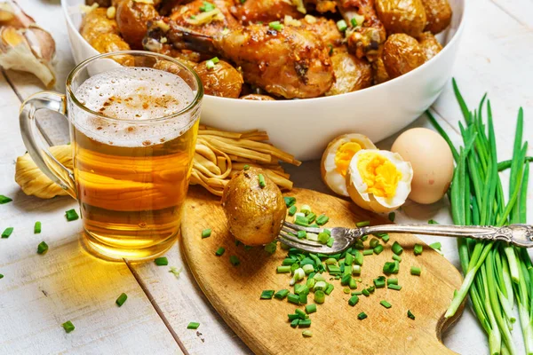 乡村风格的午餐 美味食物 一杯啤酒 炸鸡肉和土豆 大蒜和青葱 煮熟的鸡蛋和盐 用白色木板烹调的食物 — 图库照片