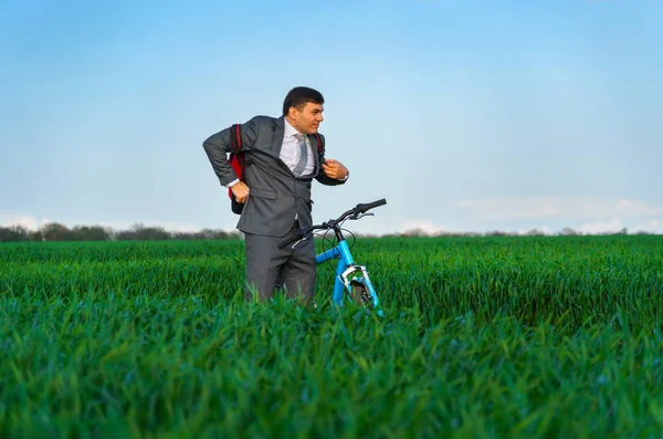 Businessman Puts Backpack Poses Bicycle Green Grass Field Dressed Business — Stock Photo, Image