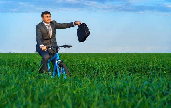 사업가는 작업복을 풀밭을 자전거를 다니며 서류를 가지고 있습니다 아름다운 컨셉이죠 로열티 프리 스톡 사진