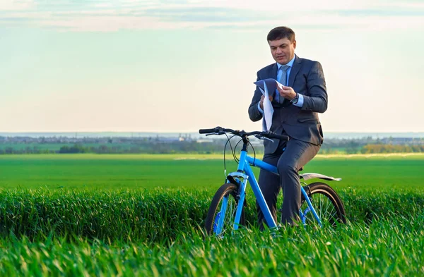 緑の草原 春の美しい自然 ビジネスコンセプトを通じて自転車を報告書や文書でビジネススーツを着たビジネスマン — ストック写真