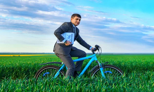 緑の草原 春の美しい自然 ビジネスコンセプトを通じて自転車を報告書や文書でビジネススーツを着たビジネスマン — ストック写真
