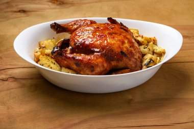 Kızarmış tavuk eti ve kızarmış patates, ahşap arka planda lezzetli yemekler.