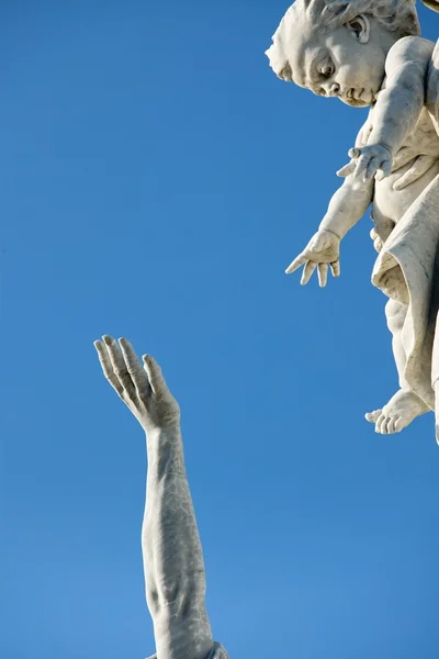 Estatua religiosa mostrando la mano del hombre tratando de llegar a la mujer sosteniendo al niño — Foto de Stock