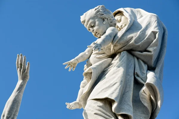 Estátua religiosa mostrando mão homem tentando alcançar mulher segurando criança — Fotografia de Stock