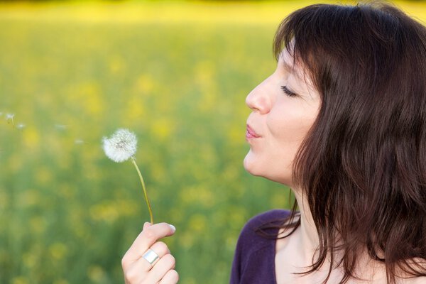 woman blowing dandelion