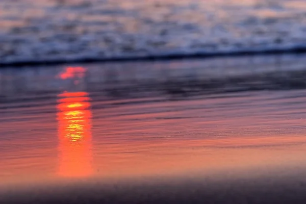 Red rays of sunlight on the sand — Stock Photo, Image