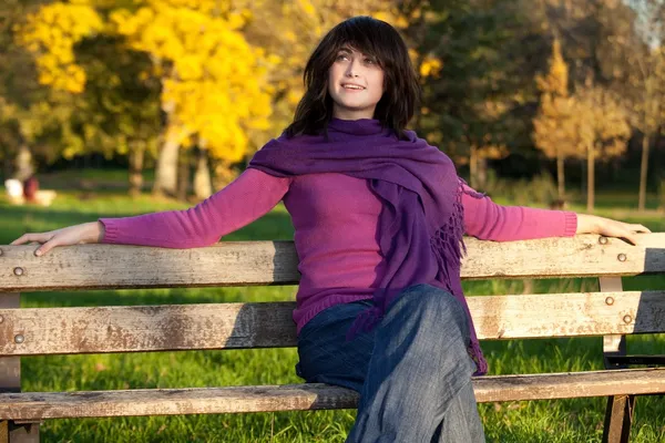 Giovane donna seduta sulla panchina del parco — Foto Stock