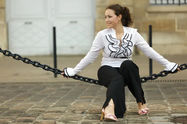 Woman sitting on chain — Stock Photo, Image