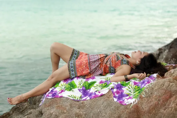 Woman resting on rocky beach — Stock Photo, Image