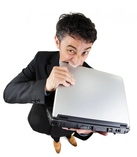 Frustrated businessman biting his laptop — Stock Photo, Image