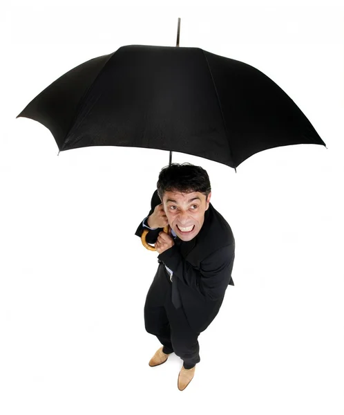 Squeamish business cowering under an umbrella — Stock Photo, Image