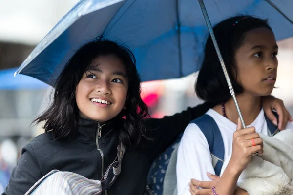 Zwei Filiapina-Mädchen unter einem Regenschirm — Stockfoto