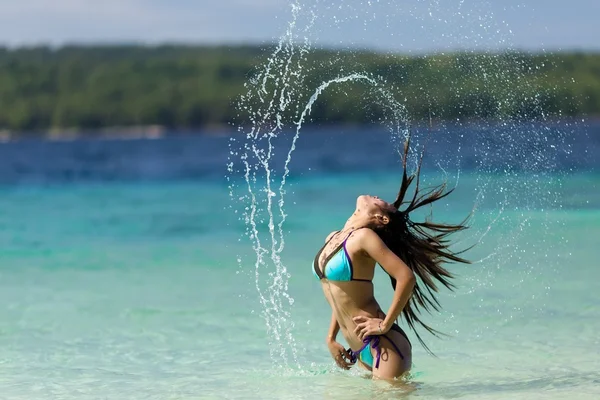 Deniz kenarında uzun saçları flicking kadın — Stok fotoğraf