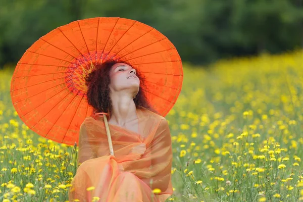 Bella donna elegante con un ombrello arancione — Foto Stock