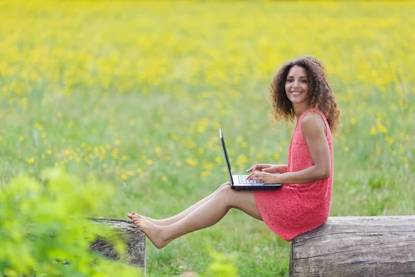 Młoda kobieta korzysta z laptopa w przyrodzie — Zdjęcie stockowe