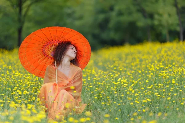 Beautiful elegant woman with an orange umbrella — Stock Photo, Image