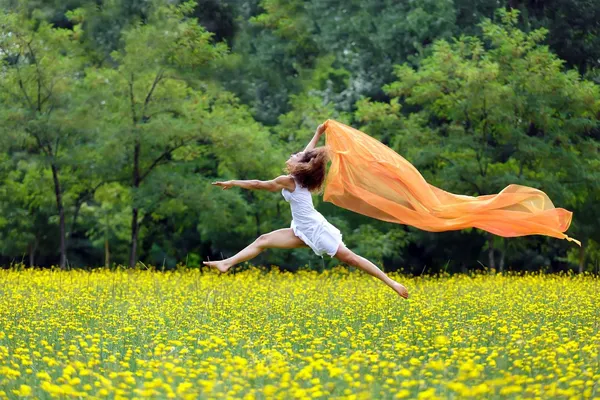 Mujer ágil saltando en el aire siguiendo una bufanda — Foto de Stock