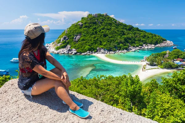 タイのコ ユアン島の牧歌的な風景を見る上の岩の上に座っているアジアの女性 — ストック写真