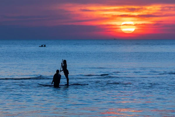 Denizde Renkli Bir Gün Batımının Üzerinde Iki Insan Silueti — Stok fotoğraf