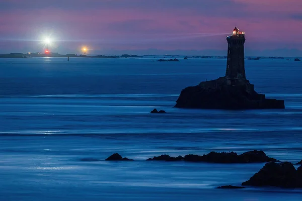 Night exposure of the famous La Vieille lighthouse illuminated with Sein island and Ar-Men lighthouse at the back, Brittany, France