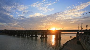 nehir kıyısında günbatımı ve alacakaranlık gökyüzü arasında köprü