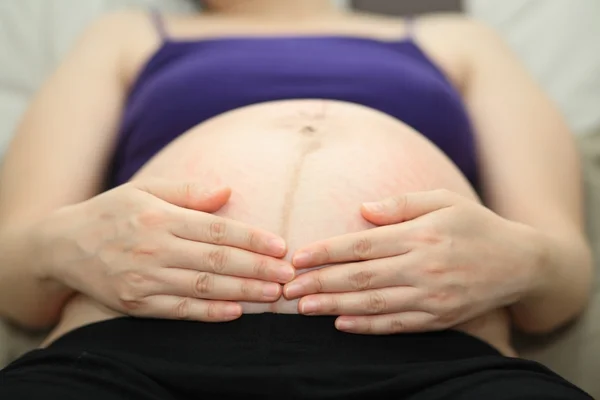 Schwangere berührt ihren Bauch — Stockfoto