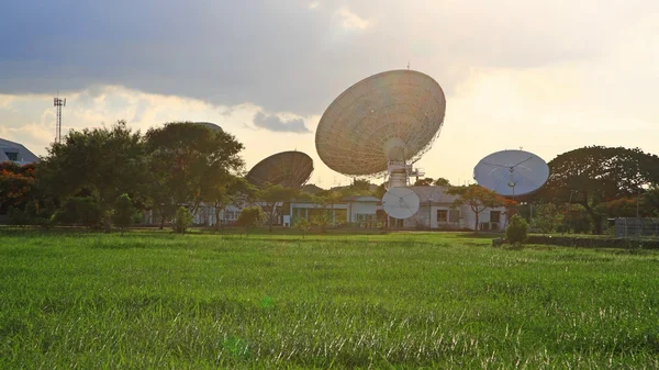Satellite communication dish against flare light — Stock Photo, Image