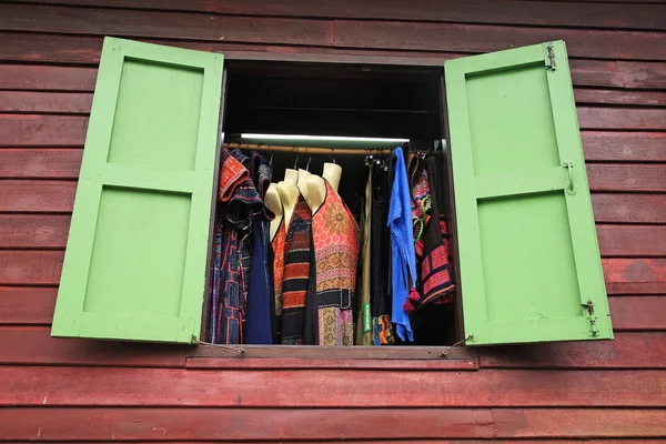 Местный магазин модной одежды через деревянные окна — стоковое фото