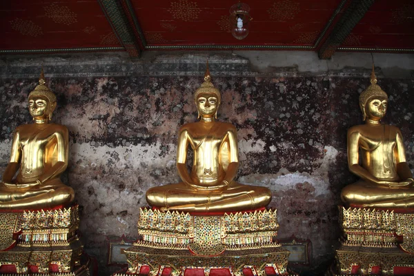 Złote posągi Buddy w korytarzu w wat suthat — Zdjęcie stockowe