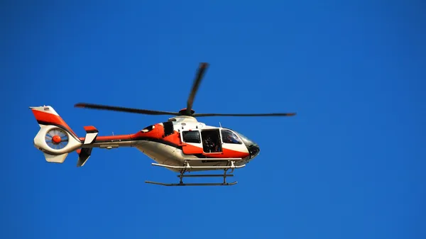 helicopter with blur propeller at blue sky