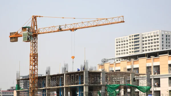 Site de construction avec grue jaune et les travailleurs — Photo