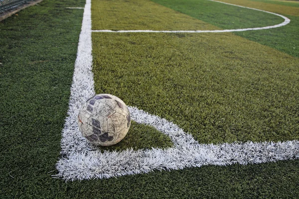 Pelota vieja en el nuevo campo de fútbol en la esquina —  Fotos de Stock