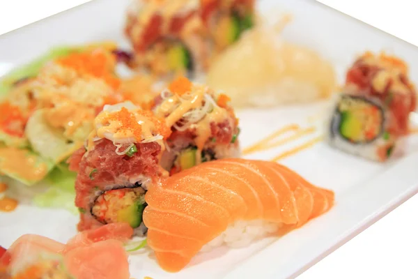 Sushi łososia i tuńczyka pikantne Roladki na płytkę na białym tle — Zdjęcie stockowe