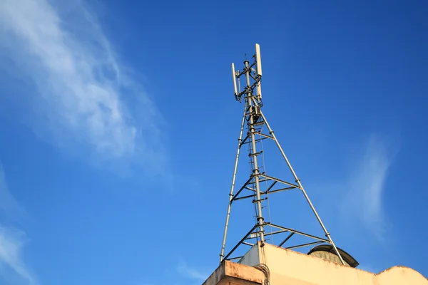 Cell Phone Tower on building against blue sky — Stock Photo, Image