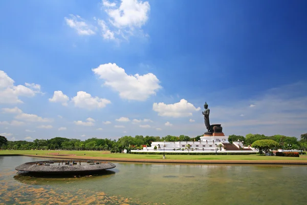 Big black standing buddha with water reflection — Stock Photo, Image