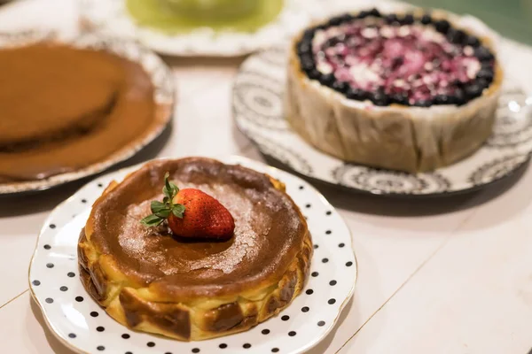 ストロベリーチーズケーキとブルーグリーンティー ホワイトウッドテーブルのチョコレートケーキ 夕食を祝うために多くの誕生日ケーキ — ストック写真