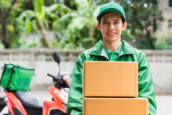 Χαμογελαστός Κούριερ Deliverymanσε Πράσινο Σακάκι Ομοιόμορφη Δώσει Κουτιά Δεμάτων Φόντο — Φωτογραφία Αρχείου