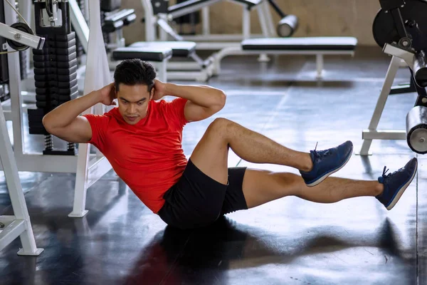 Spor salonunda altı paket (üst ve alt karın kasları ve eğik kaslar) yapmak için Asyalı sporcu kaslı bisiklet çatırtısı. Vücut geliştirme, spor ve sağlıklı yaşam tarzı konsepti.