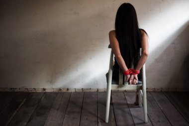 Rehine kadın kırmızı bir iple bağlanmış. Terk edilmiş bir evde, pencere kenarındaki ışıkla. Teröristler tarafından kaçırılan ya da kaçırılan kadınlar. Metin için kopya alanı olan pis odada cinsel istismar ya da tecavüz.